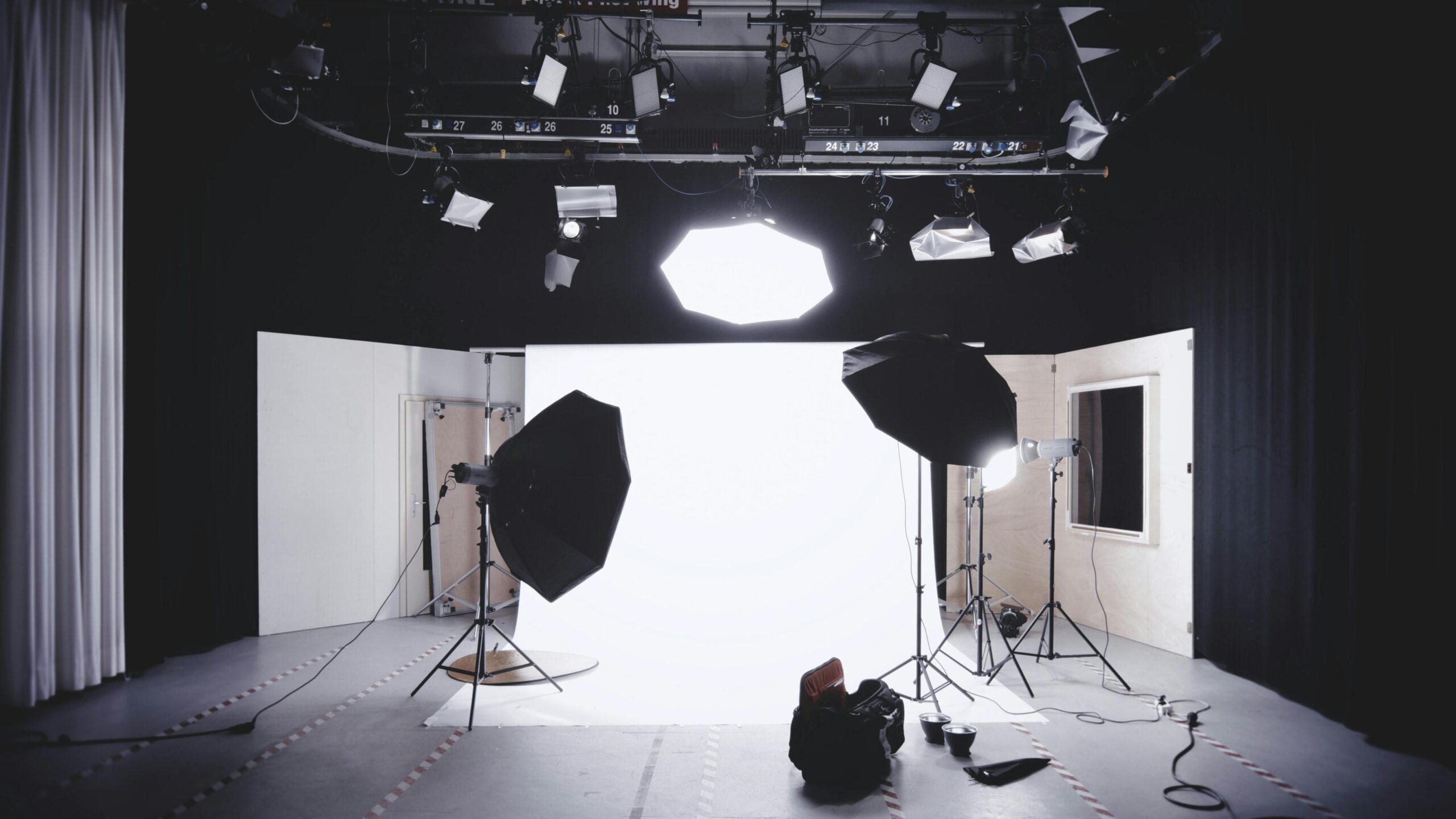 A well-equipped photography studio featuring lights, softboxes, and a white backdrop for professional shoots.